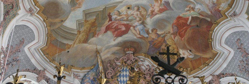 Detail des Freskos in der im Rockokko-Stil wieder errichteten Kirchenapsis. Auf dem Broncegitter ist das franziskanische Wappen mit den über Kreuz liegenden Armen angebracht. 